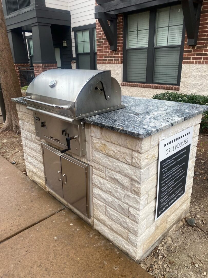 A grill that is sitting on top of a brick wall.
