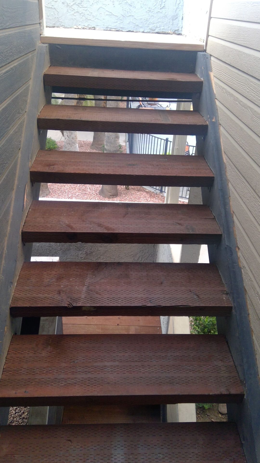 A wooden staircase with no railing and no handrail.